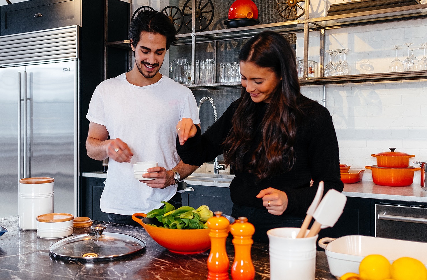 A man and woman kick up a storm in the kitchen.